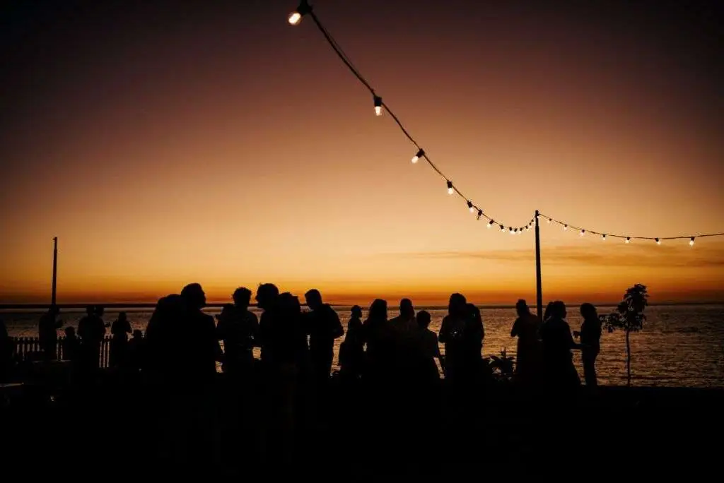 Sunset party silhouettes by water